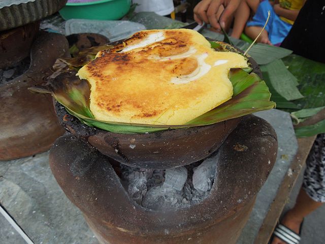 Bibingka is a Filipino cake made with ground glutinous rice, coconut milk and eggs, lined with banana leaves, and cooked in clay pots. Photo by Judgefloro.